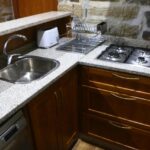 Cozinha da Casa do Poço, equipada com placa, torradeira, maquina de café, máquina de lavar a loiça, microondas e frigorífico combinado